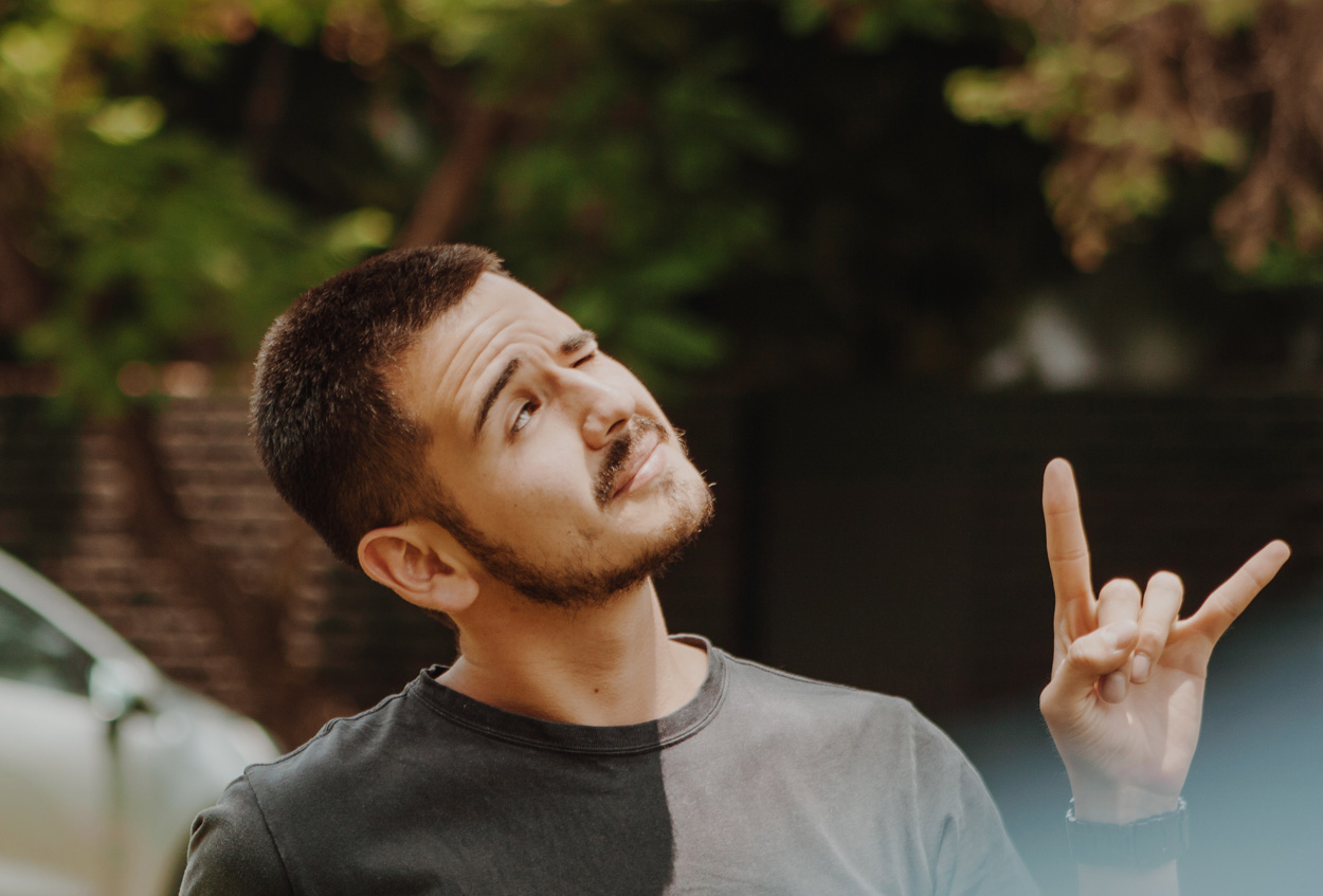 man blinking making the horns sign