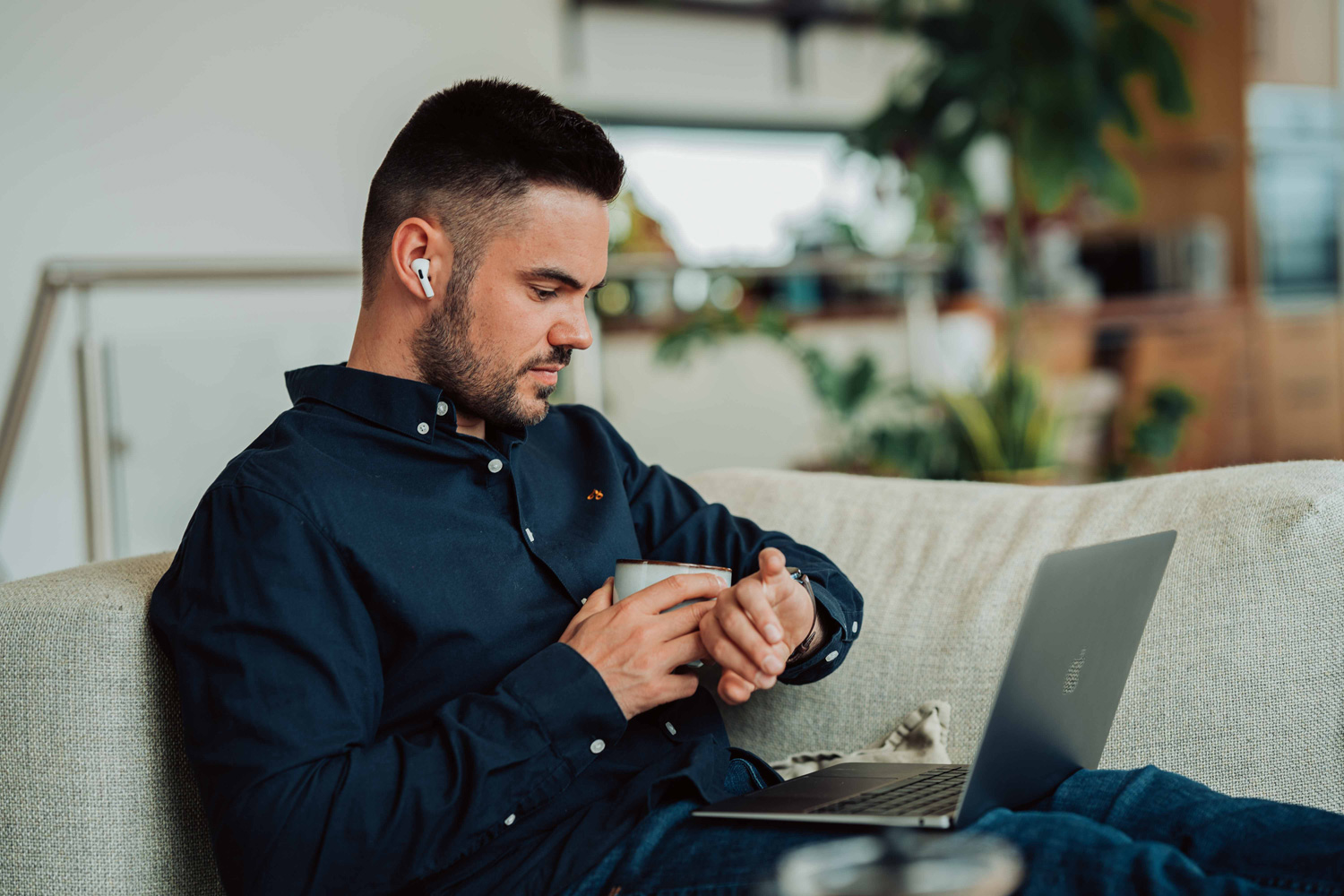 man siting on the couch using laptop