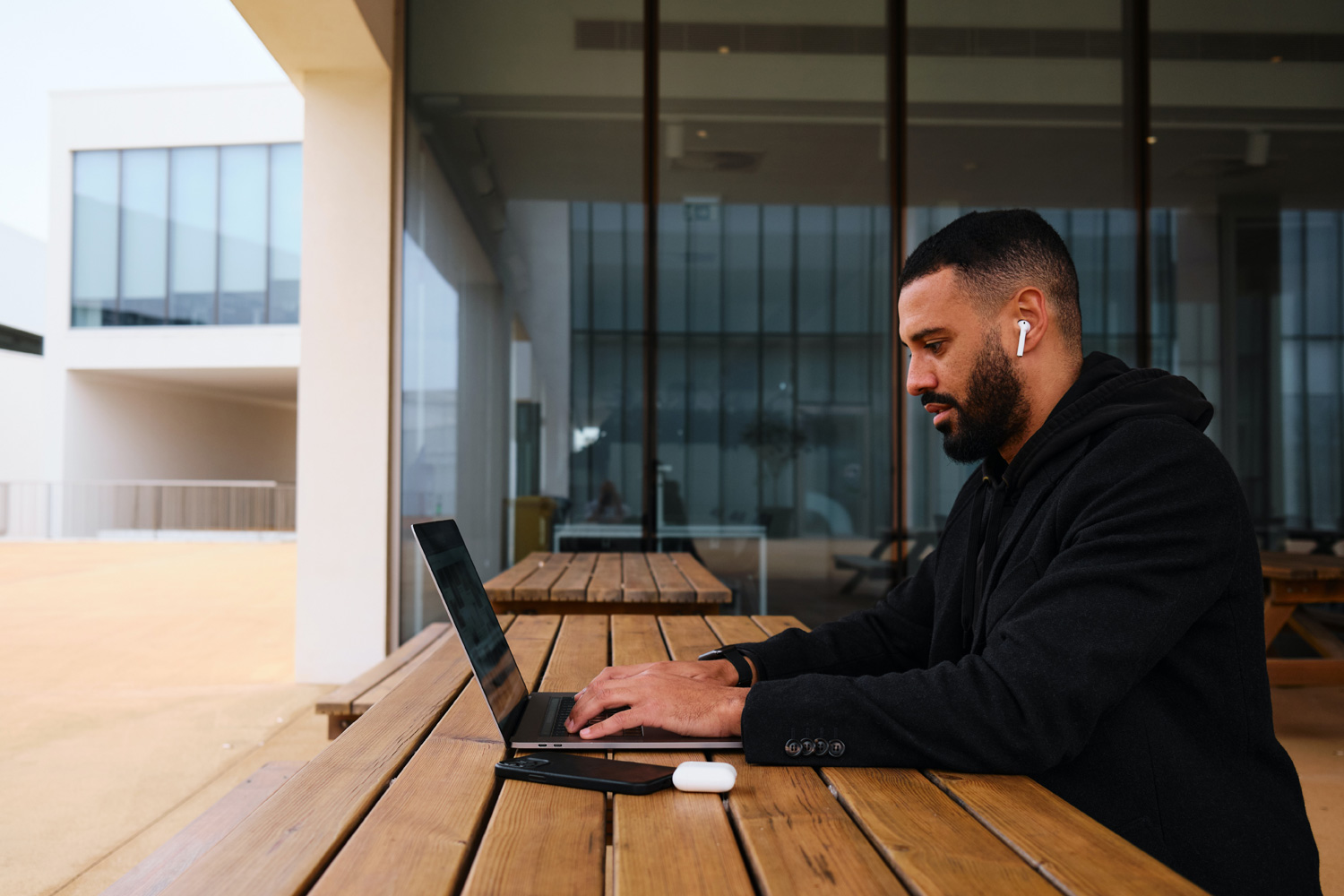 man sitting at table using laptop