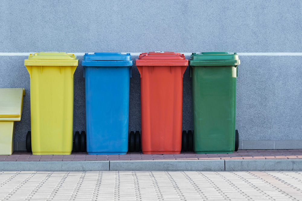 recycling bins lined up on the sidewalk