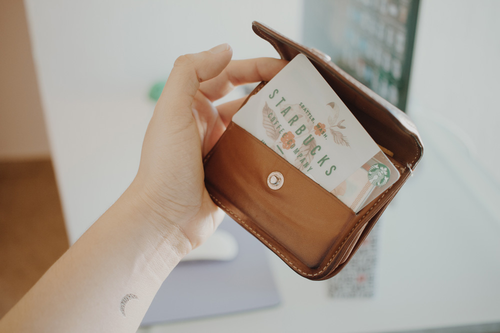 woman holding starbucks gift card in wallet