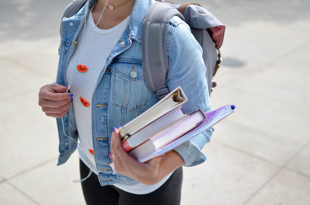 woman student walking holding books