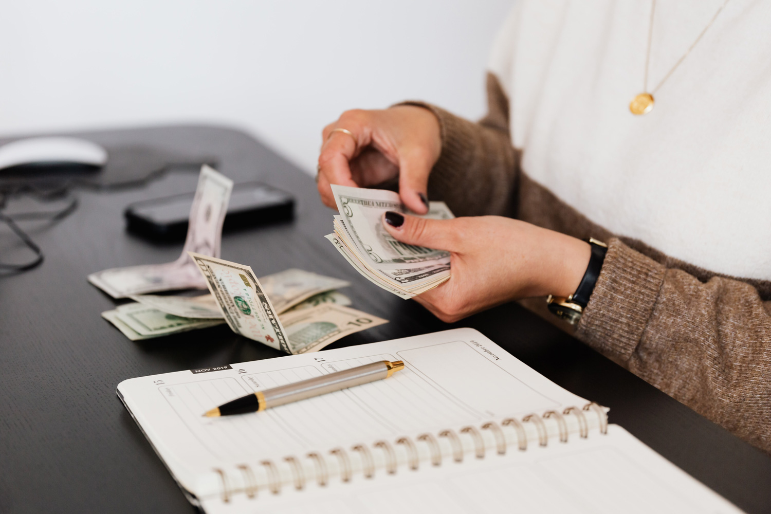 woman counting cash by a table