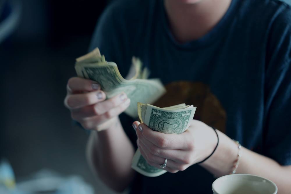 woman holding and counting dollar bills