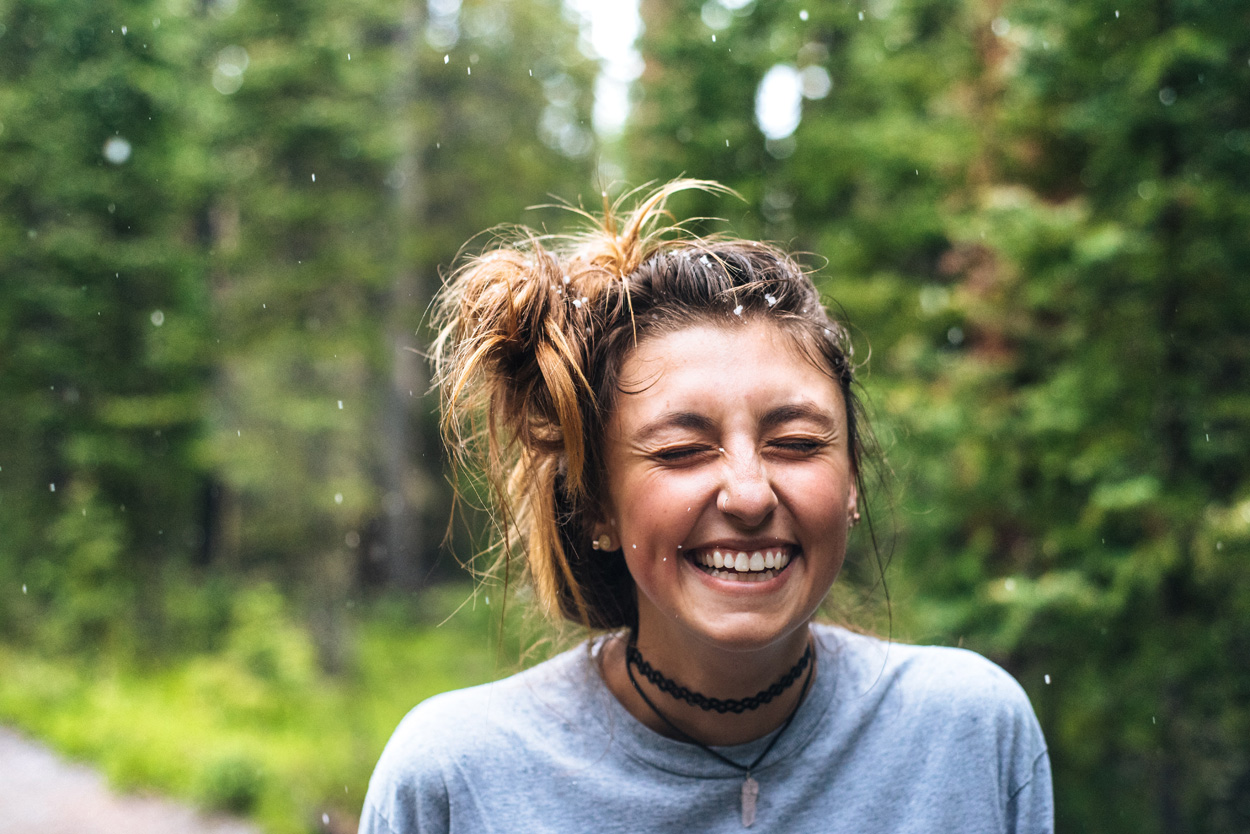 woman smiling near trees outdoors